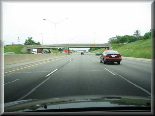 Road scene image with roadway repair materials appearing simliar to white longitudinal markers