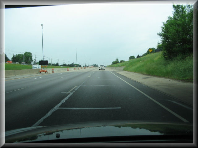 Road scene image with roadway repair materials appearing simliar to white longitudinal markers